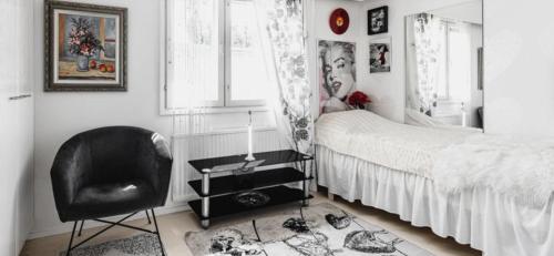 a bedroom with a black chair and a bed at Paukavuori in Seinäjoki