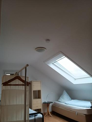 a dorm room with a bed and a skylight at Pension Urbanstraße 46 in Stuttgart