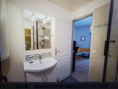 une salle de bain blanche avec un lavabo et un miroir dans l'établissement Studio au coeur de Viviers, à Viviers