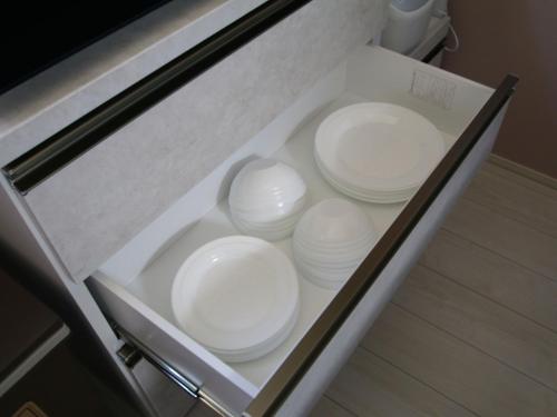 a drawer filled with white dishes in a cabinet at Casa Kikuchi in Kikuchi