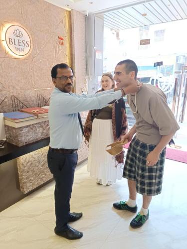 a man is touching another mans face in a store at BLESS INN - Near Connaught Place in New Delhi