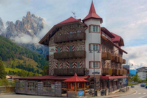 a tall building with graffiti on the side of it at Castel Madonna in San Martino di Castrozza