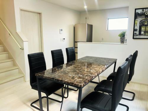 a dining room with a table and black chairs at Casa Kikuchi in Kikuchi