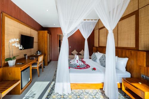 a bedroom with a bed and a desk at Puri Andong Villa in Ubud