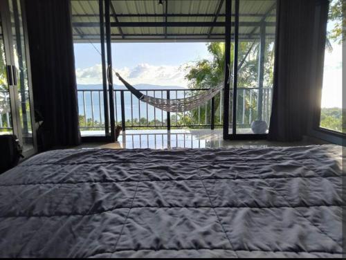 ein Schlafzimmer mit einer Hängematte und einem Bett mit Aussicht in der Unterkunft Blue and green apartments in Ban Nua