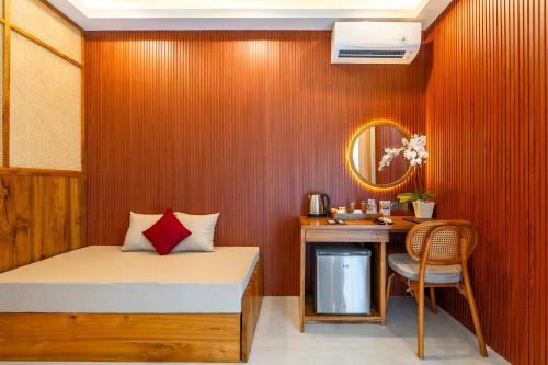 a bedroom with a bed and a desk with a chair at Puri Andong Villa in Ubud