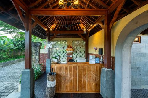 an outdoor kitchen in a house with a wooden counter at Puri Andong Villa in Ubud