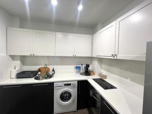 a kitchen with white cabinets and a washing machine at IN&P Apartment - top location in Veliko Tŭrnovo