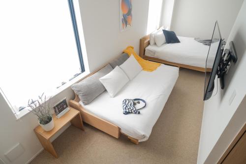 a small room with a bed and a bed and a mirror at KABIN Minamiza in Kyoto