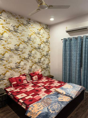 a bedroom with a bed with a quilt on it at Tirupati home stay in Ujjain