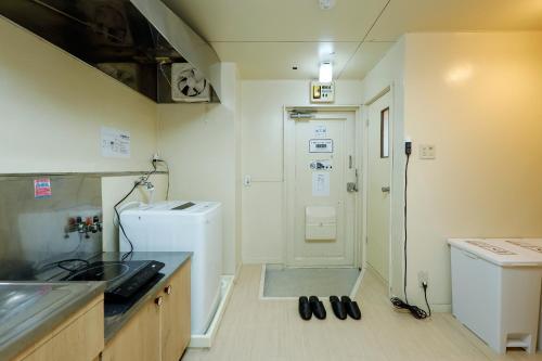 een keuken met een wastafel, een wasmachine en een droger bij Kimura House in Tokyo