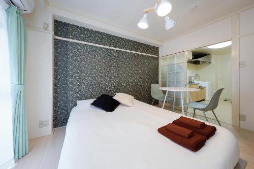 een slaapkamer met een groot wit bed en een tafel bij Kimura House in Tokyo