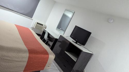 a room with a bed and a tv on a wall at Evergreen Inn & Suites Portland in Portland