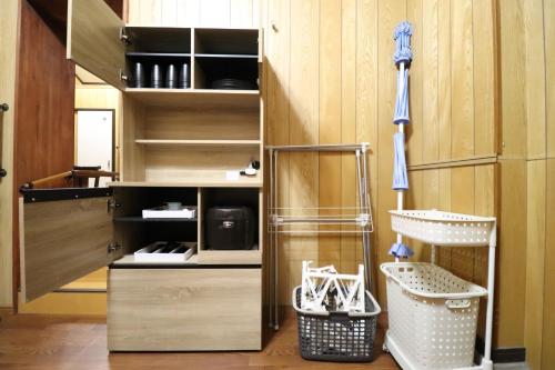 a kitchen with wooden cabinets and shelves with baskets at Ideal Momodani イデアール桃谷 in Osaka