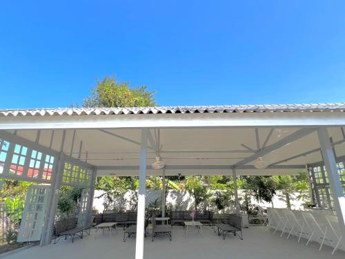 a patio with tables and chairs under a pavilion at Garden House Rice Field and Mountain View in Luang Prabang