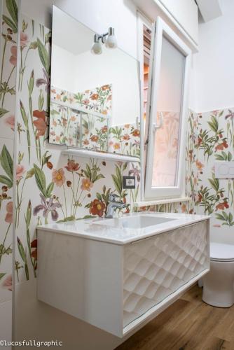 a bathroom with a white tub and flowers on the wall at Sophie's Choice in Rome
