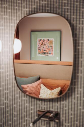 a mirror on a wall with a picture in a room at SchönBerg hotel b&b in Rio Bianco
