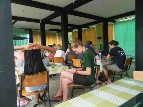 a group of people sitting at tables in a restaurant at Birds Paradise Hotel in Kudawe