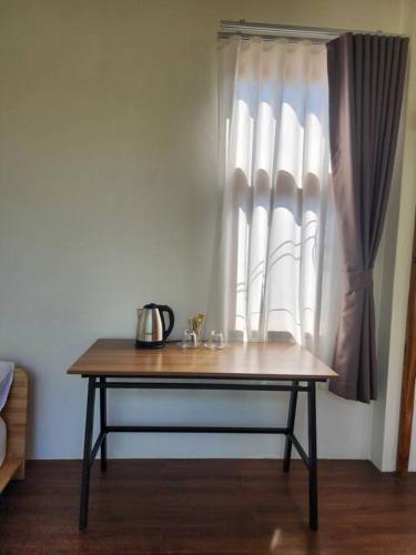 a wooden table in front of a window at Rimtara Nan ริมธารา น่าน in Ban Khia