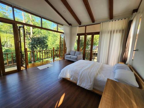 a bedroom with a bed and a balcony at Rimtara Nan ริมธารา น่าน in Ban Khia
