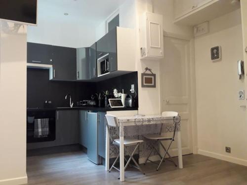 une cuisine avec une table et des chaises dans une pièce dans l'établissement Studio l'Impérial- 3pers -Proche Centre et Plages, à Nice