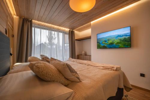 a bedroom with a large bed with a large window at Apartmán STRÖMY Demänovská dolina in Liptovský Mikuláš