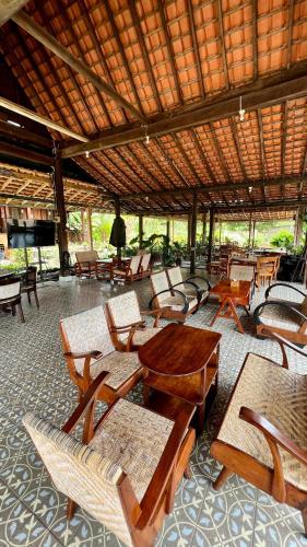 a group of tables and chairs in a pavilion at OKU Guest House in Giri