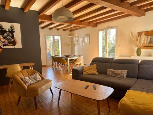 a living room with a couch and a table at Maison Familiale bord de mer in Préfailles