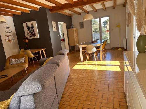 un salon avec un canapé et une table dans l'établissement Maison Familiale bord de mer, à Préfailles