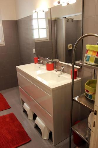 une salle de bain avec un lavabo et un miroir dans l'établissement Maison Familiale bord de mer, à Préfailles