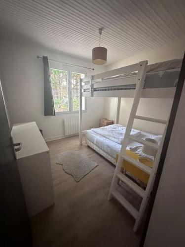 une chambre avec un lit superposé avec une échelle dans l'établissement Maison Familiale bord de mer, à Préfailles