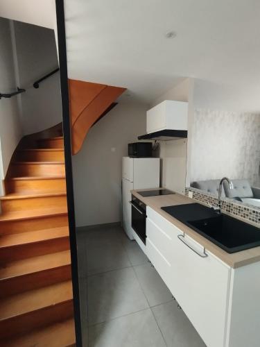 une cuisine avec un évier et un escalier dans l'établissement Maison Montebello, à Sézanne