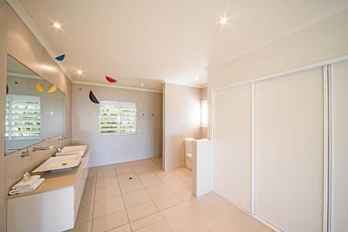 a bathroom with two sinks and a mirror at Sea Star Apartments in Airlie Beach