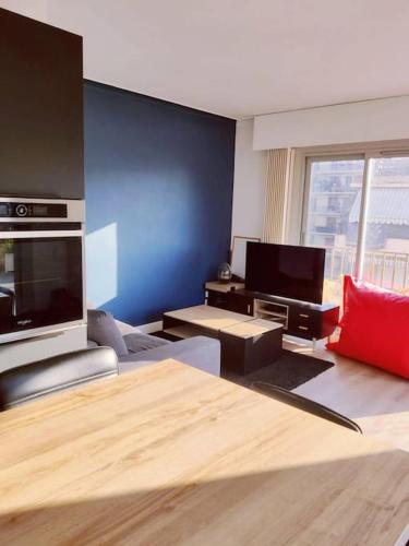 un salon avec un canapé et une télévision dans l'établissement Romantic 1BR Escape with Sun-Rooftop Terrace, à Nice