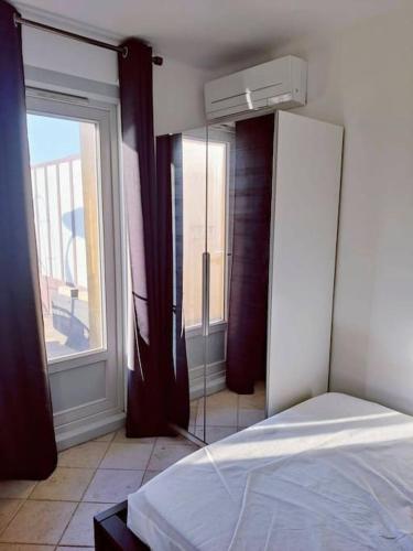 une chambre avec un lit et une grande fenêtre dans l'établissement Romantic 1BR Escape with Sun-Rooftop Terrace, à Nice