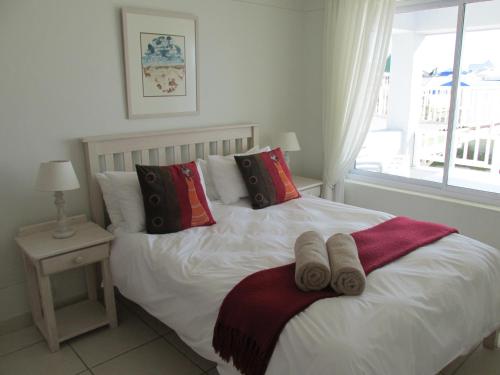 a bedroom with a bed with two towels on it at Point Village Accommodation - Alista in Mossel Bay