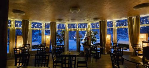 a dining room with tables and chairs and large windows at Hotel Garni Auszeit in Boltenhagen