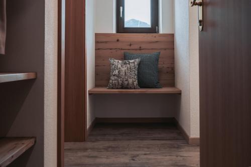 a hallway with a pillow sitting on a wooden shelf at SchönBerg hotel b&b in Rio Bianco