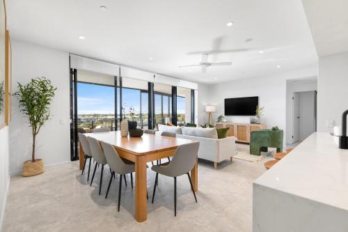 a dining room and living room with a table and chairs at Bokarina Beach Apartments, an Ascend Collection Hotel in Bokarina