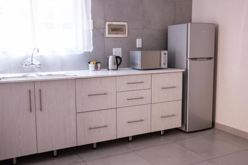 a kitchen with a refrigerator and a sink at Emerald Bed&Breakfast in Windhoek
