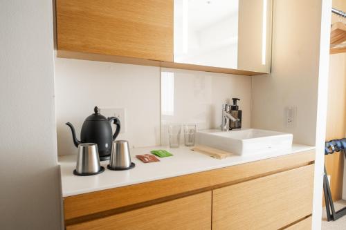 a kitchen counter with a tea kettle and a sink at KABIN Minamiza in Kyoto