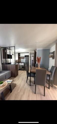 un salon avec une table, des chaises et un canapé dans l'établissement Cap-Ferret confort plage piscine à 6 by Vayny CM, à Lège-Cap-Ferret