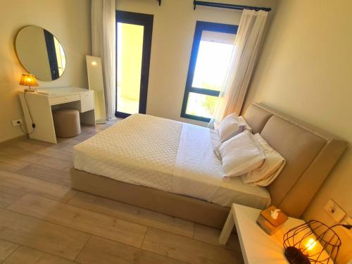 a bedroom with a large bed and a mirror at شيدوان الجونة in El Gouna