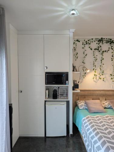 a bedroom with a bed and a microwave at Estudio con Piscina, Playa y Wifi in Denia