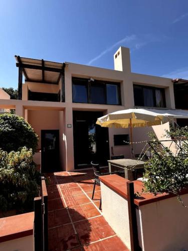 una casa con mesa y sombrilla en Portopollo sea view apartment Zero budget, en Palau