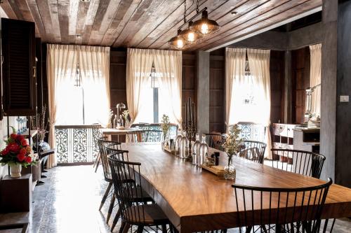 a dining room with a large wooden table and chairs at ONCE (upon a time) Chiang Mai Home in Chiang Mai