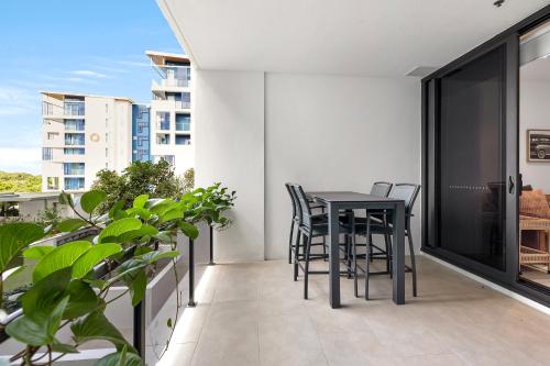 a balcony with a black table and chairs at Bokarina Beach Apartments, an Ascend Collection Hotel in Bokarina