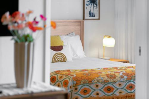 a bedroom with a bed and a vase of flowers at Bokarina Beach Apartments, an Ascend Collection Hotel in Bokarina