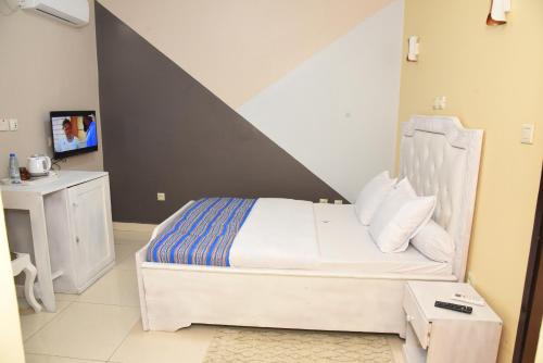 a bedroom with a bed and a tv in it at Gamo Hotel in Yaoundé