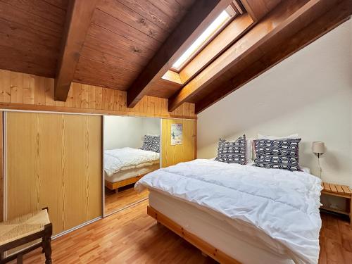 une chambre avec un grand lit et un miroir dans l'établissement PE319 - Appartement 4-5 pers pied de pistes, aux Carroz d'Arâches